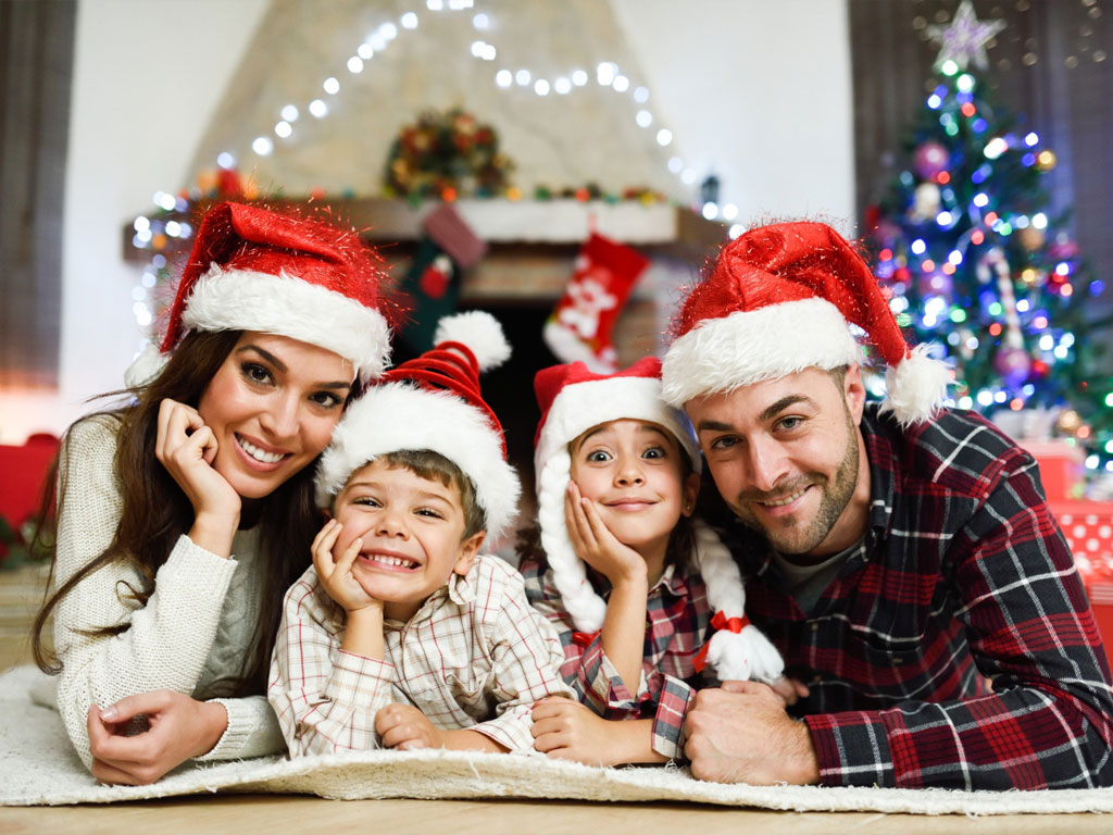 A family laying in front of the christmas tree